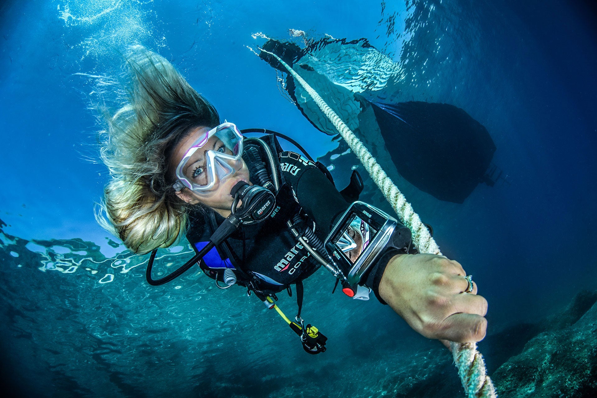 woman scuba diving along rope