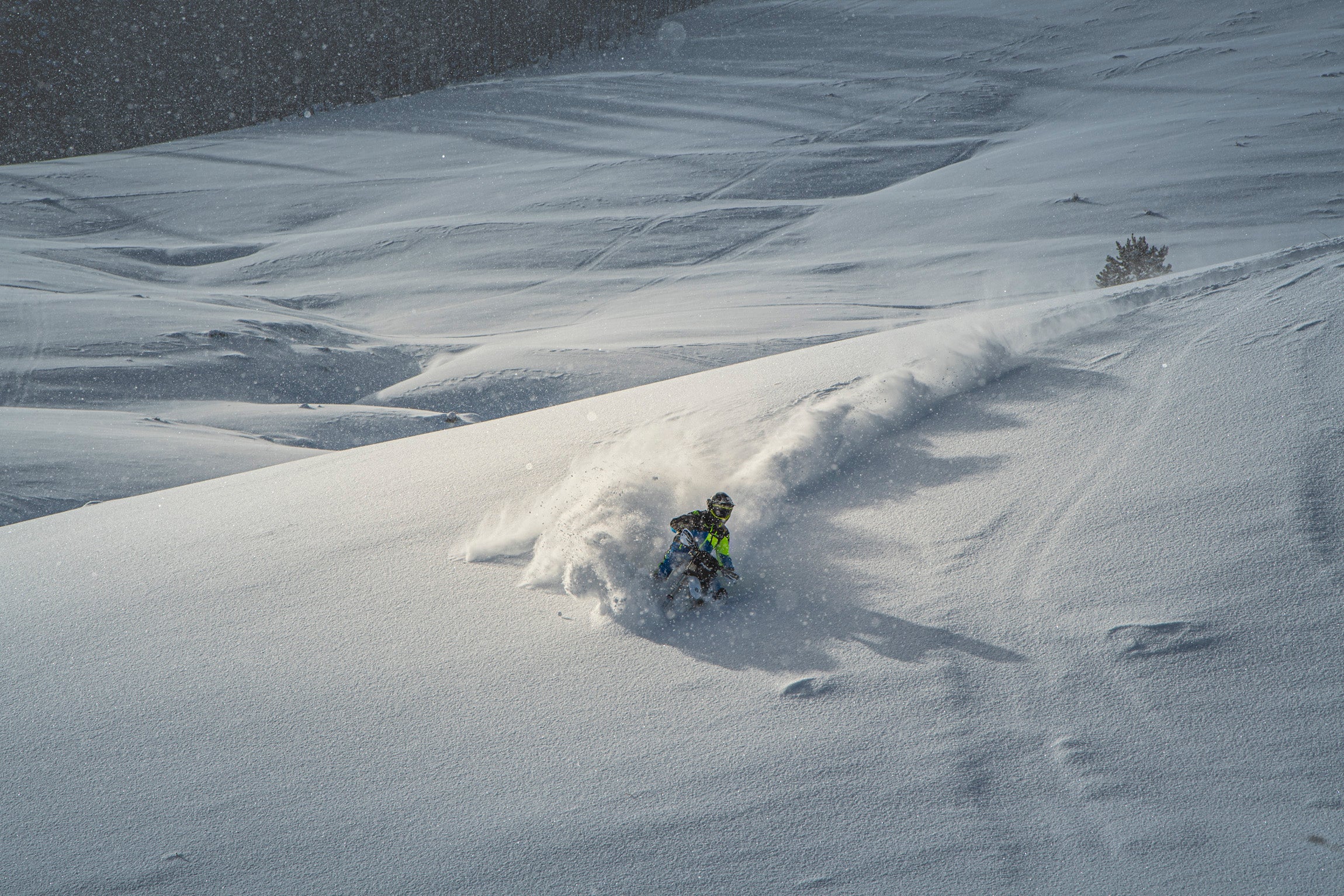 Snowbiker carving in powder