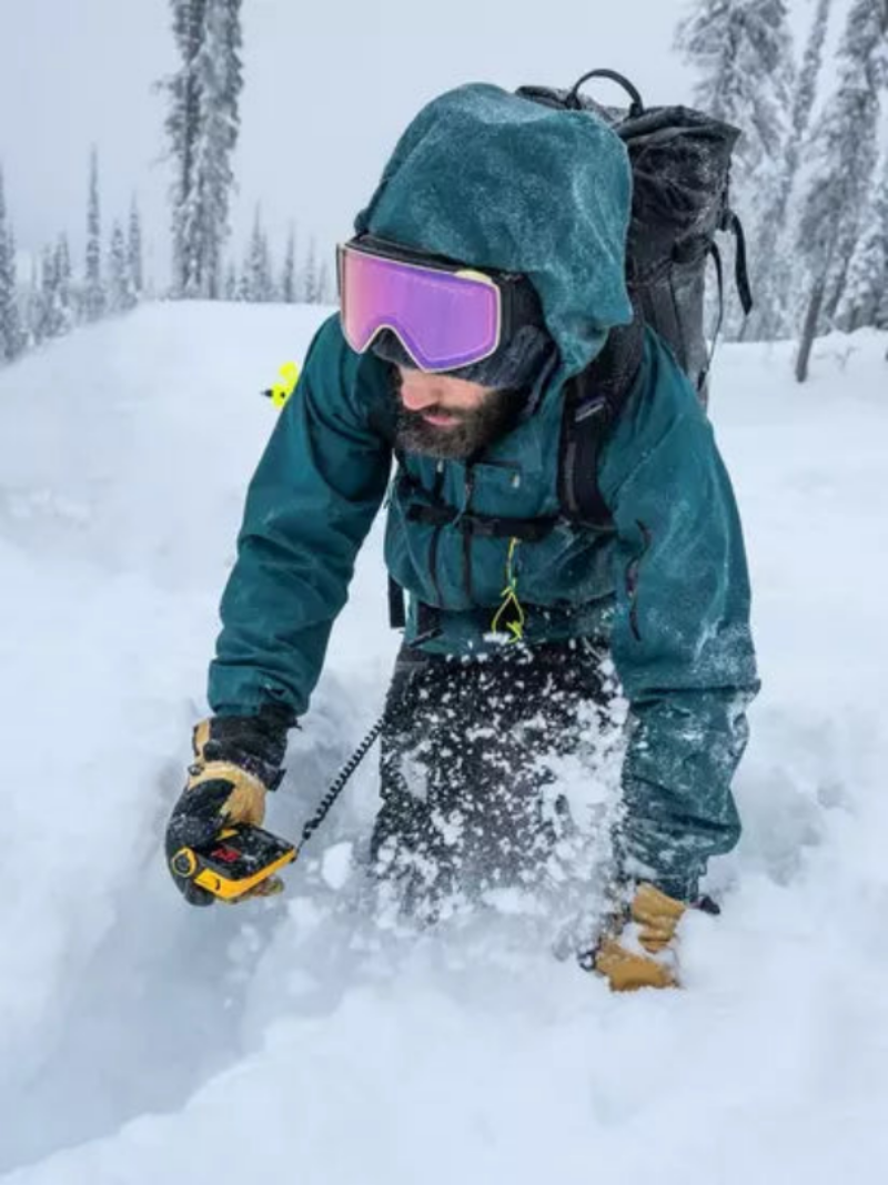 Man using snow beacon