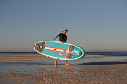 man carrying inflatable paddleboard